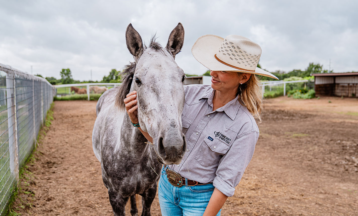 A lady comforting the horse.